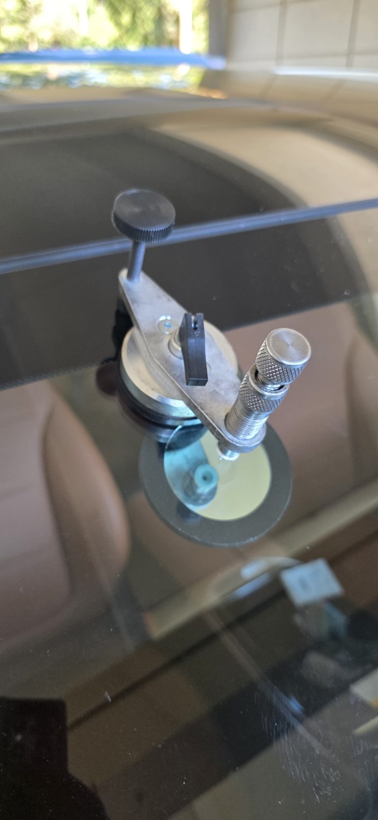 Close view of the resin injector seated over a windshield chip