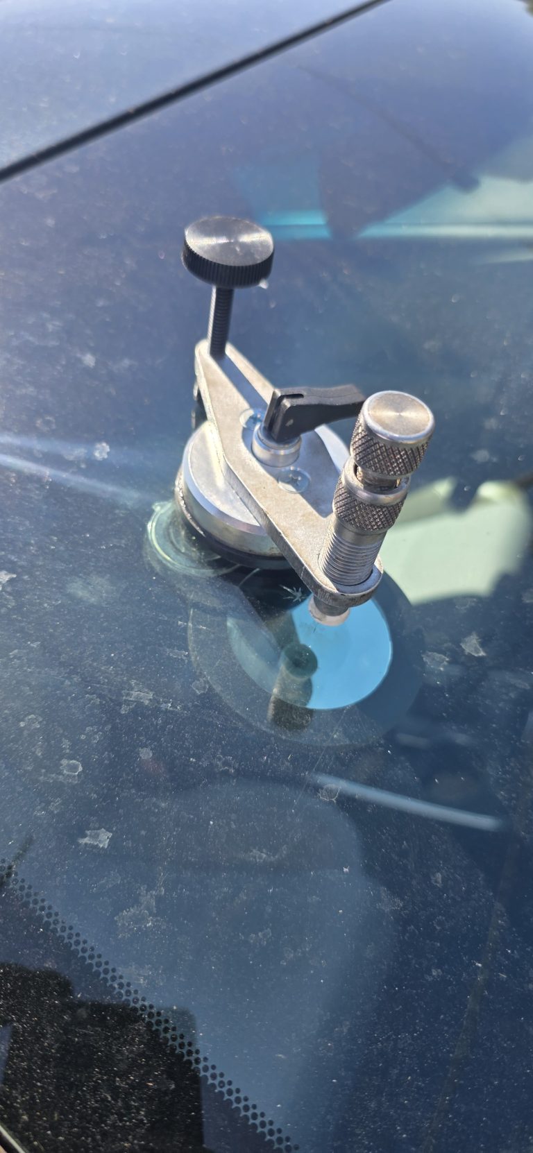 Repair injector suction-mounted to a windshield over a chip