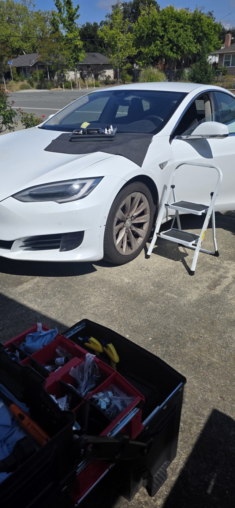 Mr. Chip mobile chip repair set up on a driveway beside a white sedan