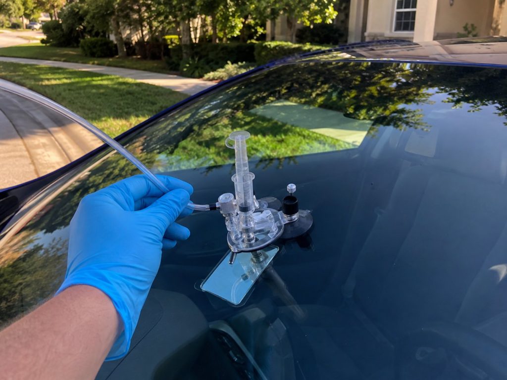 Windshield chip repair injector tool in action on vehicle glass