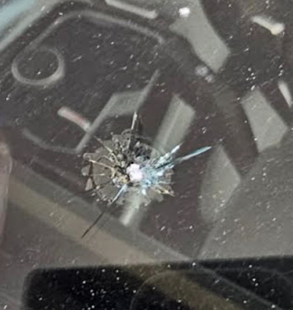 Detailed view of rock chip damage in a windshield before repair
